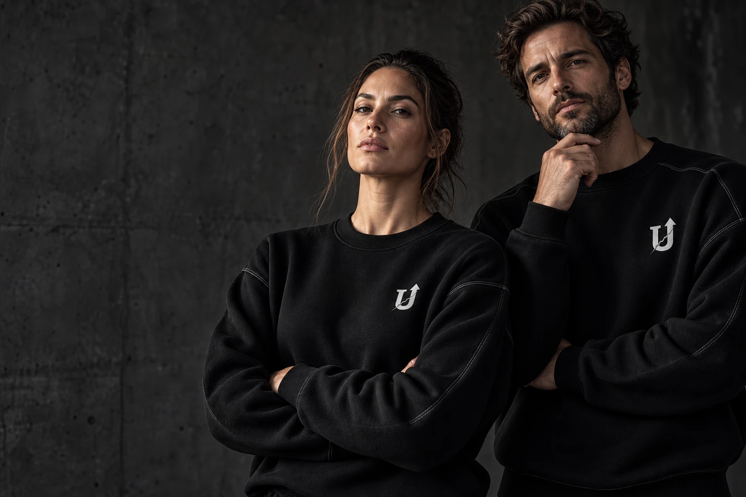 UNFRAGILE campaign concept: two adults in black crewnecks with the silver U-arrow at the chest.